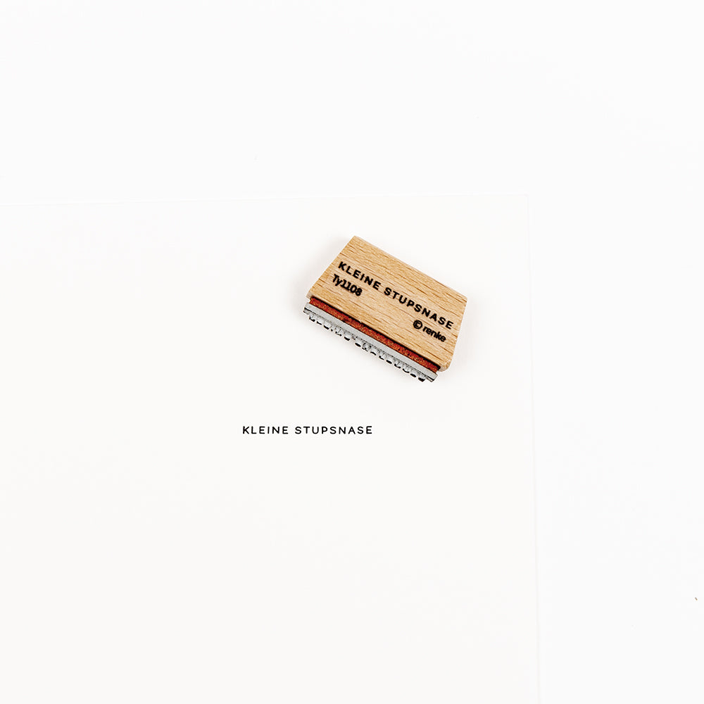 Mini-Stempel aus Holz mit der Aufschrift KLEINE STUPSNASE und einem passenden Stempelabdruck.