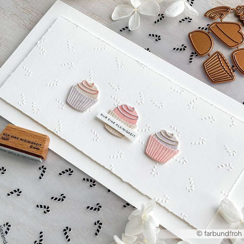 Drei pastellfarbene Cupcakes auf einer weißen Karte mit winzigen schwarzen Ameisenabdrücken und Dekorationen zum Thema Backen - mit zarten Alexandra Renke-Elementen - perfekt für charmante Papierprojekte.