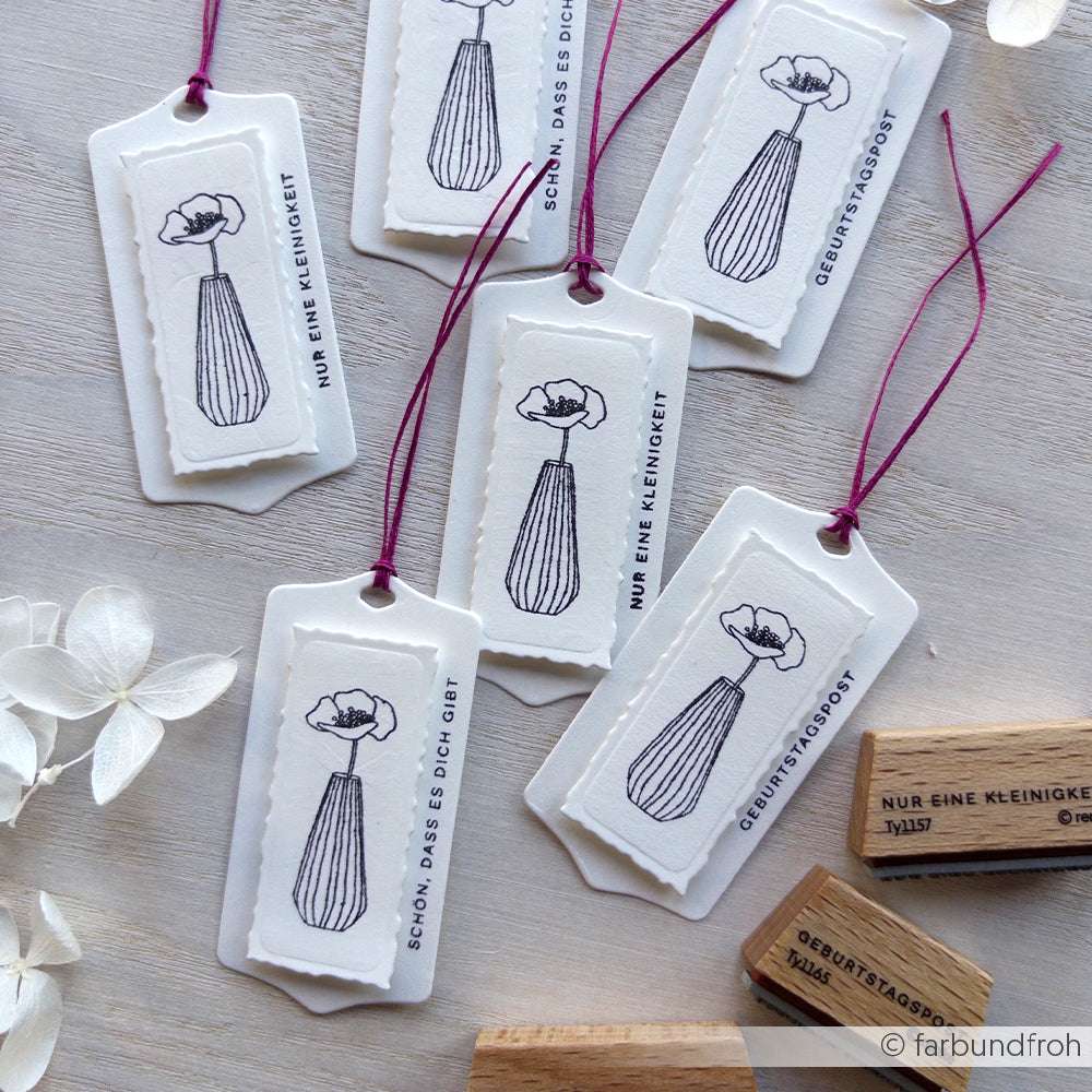 Die sechs weißen Geschenkanhänger von Alexandra Renke mit Blumenvasen-Illustrationen und deutschem Text sind ideal für Geburtstagspost oder Papierprojekte. Sie werden mit lilafarbenen Schnüren auf einer Holzfläche befestigt.