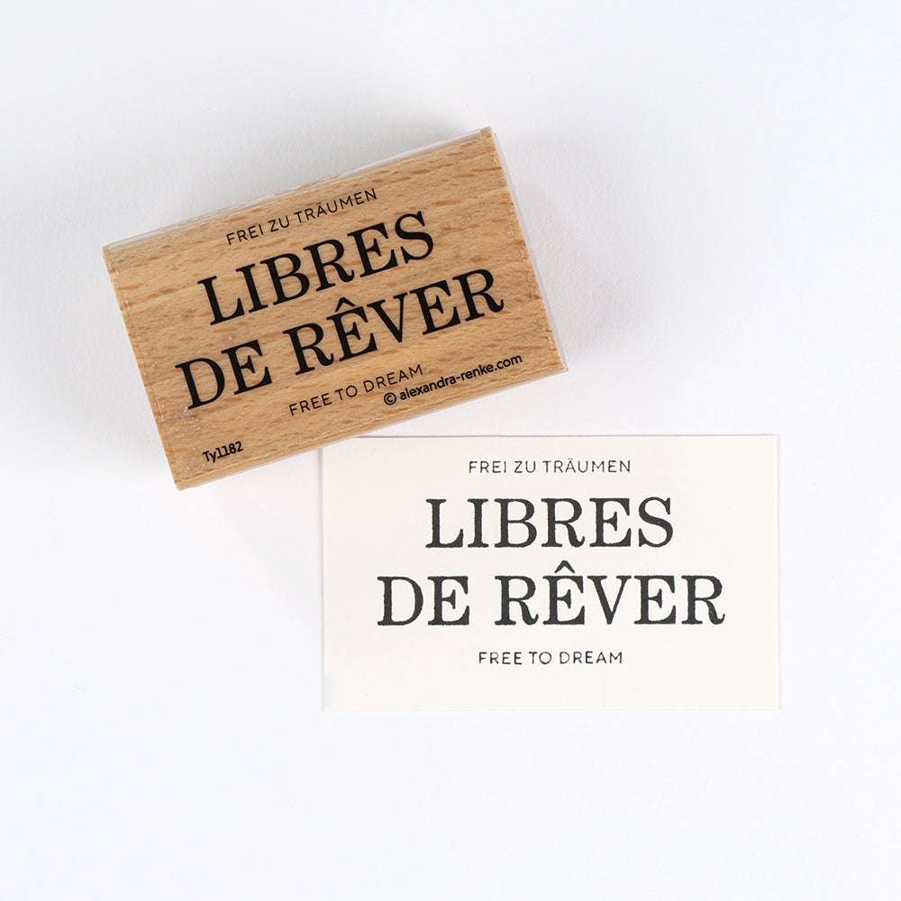 Ein hochwertiger Holzstempel und Papierdruck von Alexandra Renke, beide mit "LIBRES DE RÊVER. FREE TO DREAM"-perfekt für deine Papierprojekte.