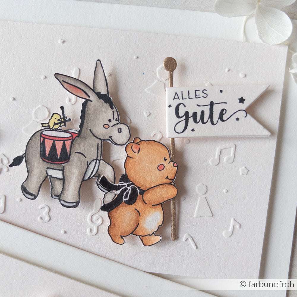 Ein Bär mit einer Schleife und ein Esel mit einem Küken auf einer Trommel halten eine "Alles Gute"-Fahne auf dieser weißen, strukturierten Karte von Alexandra Renke - perfekt für Papierprojekte oder in Kombination mit Ihrem Lieblingsholzstempel.