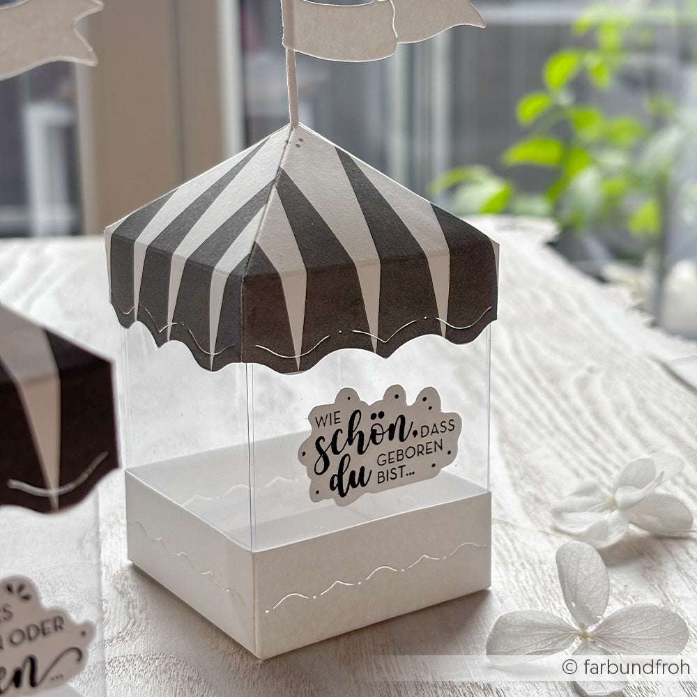 Eine durchsichtige Box von Alexandra Renke mit einem schwarz-weiß gestreiften Deckel, mit deutscher Botschaft und Flagge, hergestellt aus hochwertigen Materialien für lange Haltbarkeit.