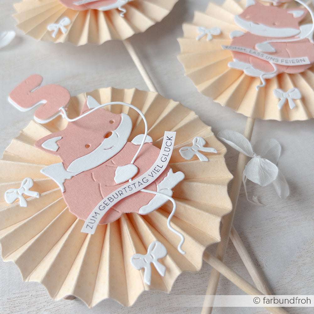 Papierrosetten von Alexandra Renke mit rosa Füchsen, Schleifen und Geburtstagswünschen sind charmante Papierprojekte für festliche Dekorationen.