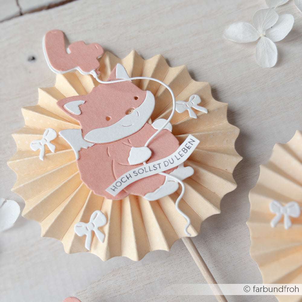 Ein niedlicher Papierfuchs mit Luftballon sitzt auf einer plissierten Rosette mit der Aufschrift HOCH SOLLST DU LEBEN" - perfekt für Bastelprojekte oder in Kombination mit Ihrem Lieblingsholzstempel von Alexandra Renke.