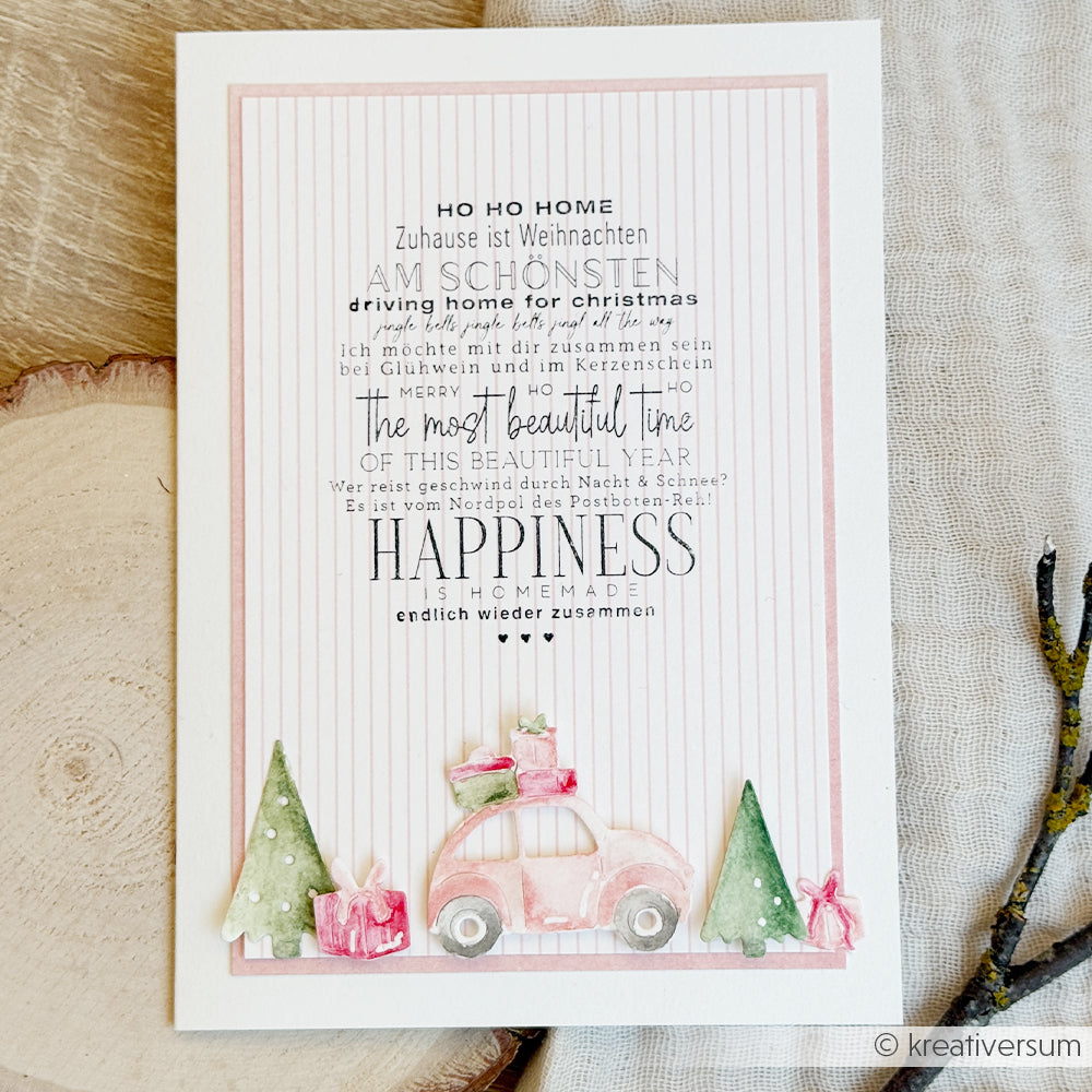 Weihnachtskarte mit festlichem Text auf Deutsch und Englisch, einem rosa Auto und Bäumen im Aquarellstil von Stempelgummi.