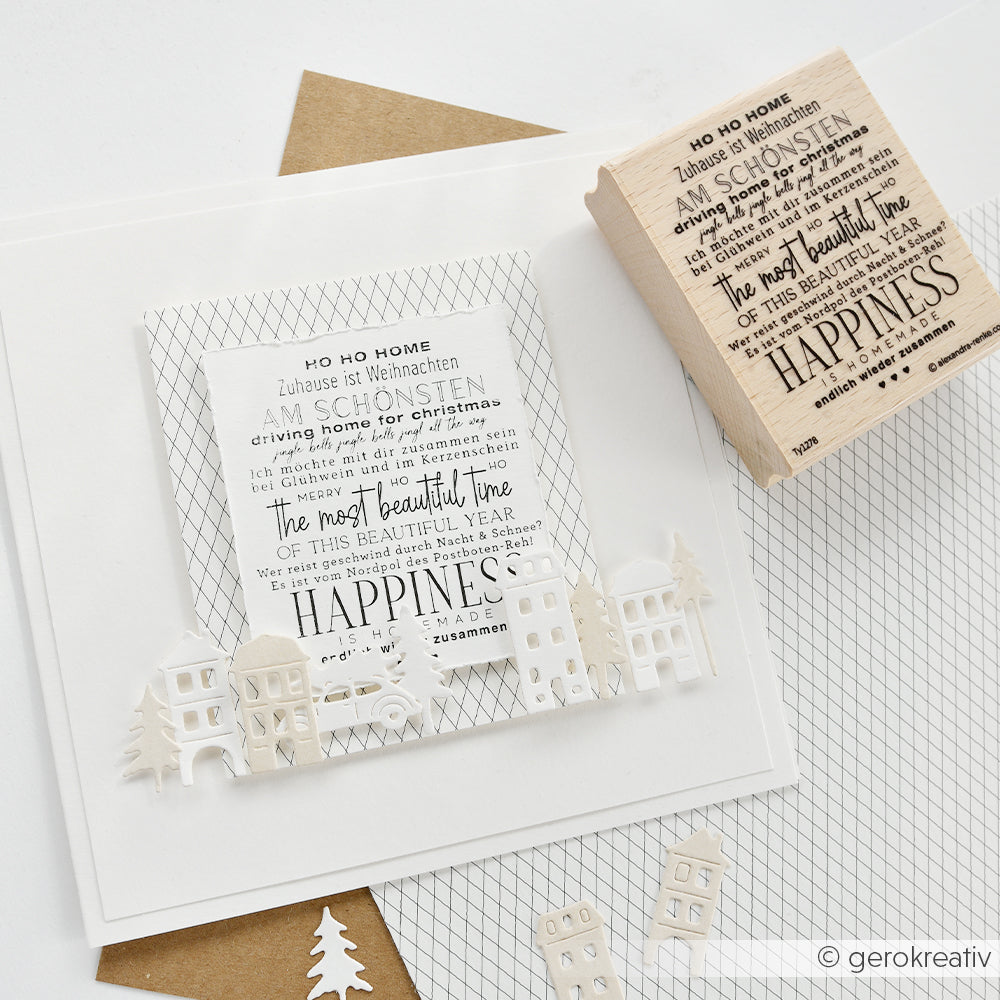 Eine Weihnachtskarte mit einem aus Papier ausgeschnittenen Dorf und einem passenden Holzstempel.