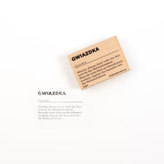 Eine Holzkarte und eine dazu passende Papierkarte mit der Aufschrift „Gwiazdka“ sowie einer deutschen Erklärung des polnischen Wortes – ideal für Holzstempel und Papierprojekte.
