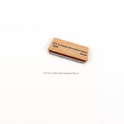 Ein Weihnachtsstempel aus Holz, auf dem über dem Stempelabdruck der Text „Ein kleines Weihnachtsnix“ aufgedruckt ist.