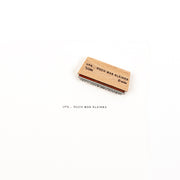 Ein Mini-Typo-Stempel aus Holz mit der Aufschrift „UPS… DOCH WAS KLEINES“ und dessen Abdruck auf einer weißen Fläche.