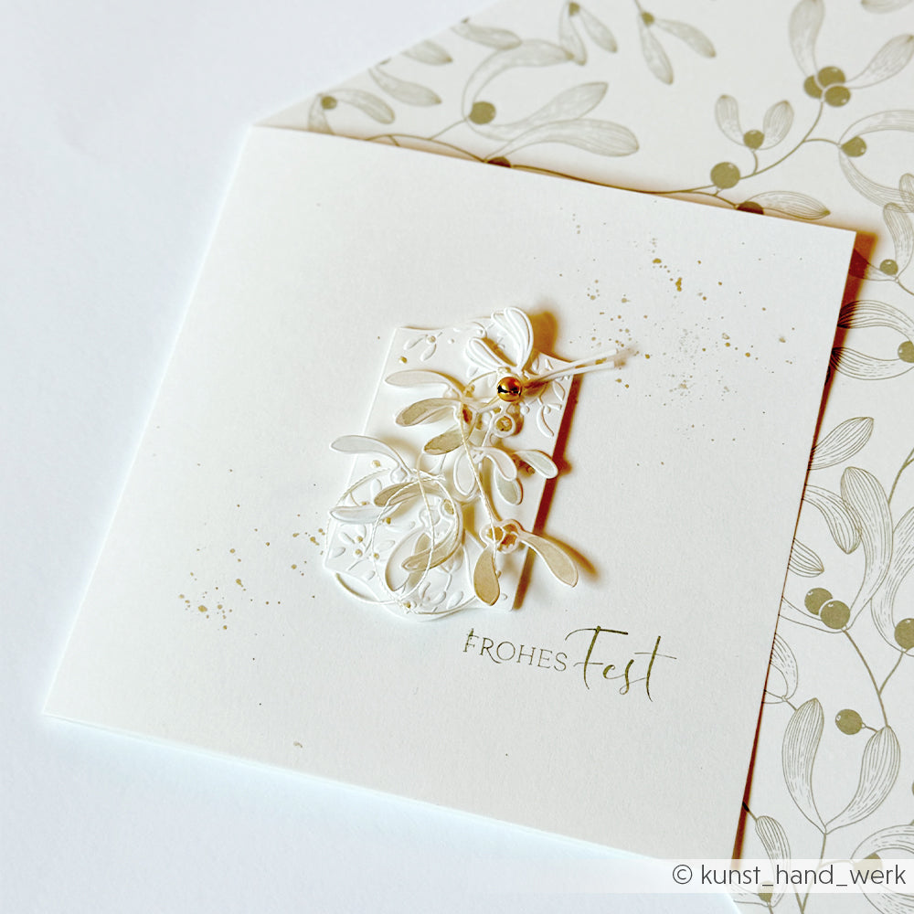 Quadratische Weihnachtskarte mit einem Mistelzweig-Motiv und einem Stempelgummi-Stempel mit der Aufschrift Frohes Fest.