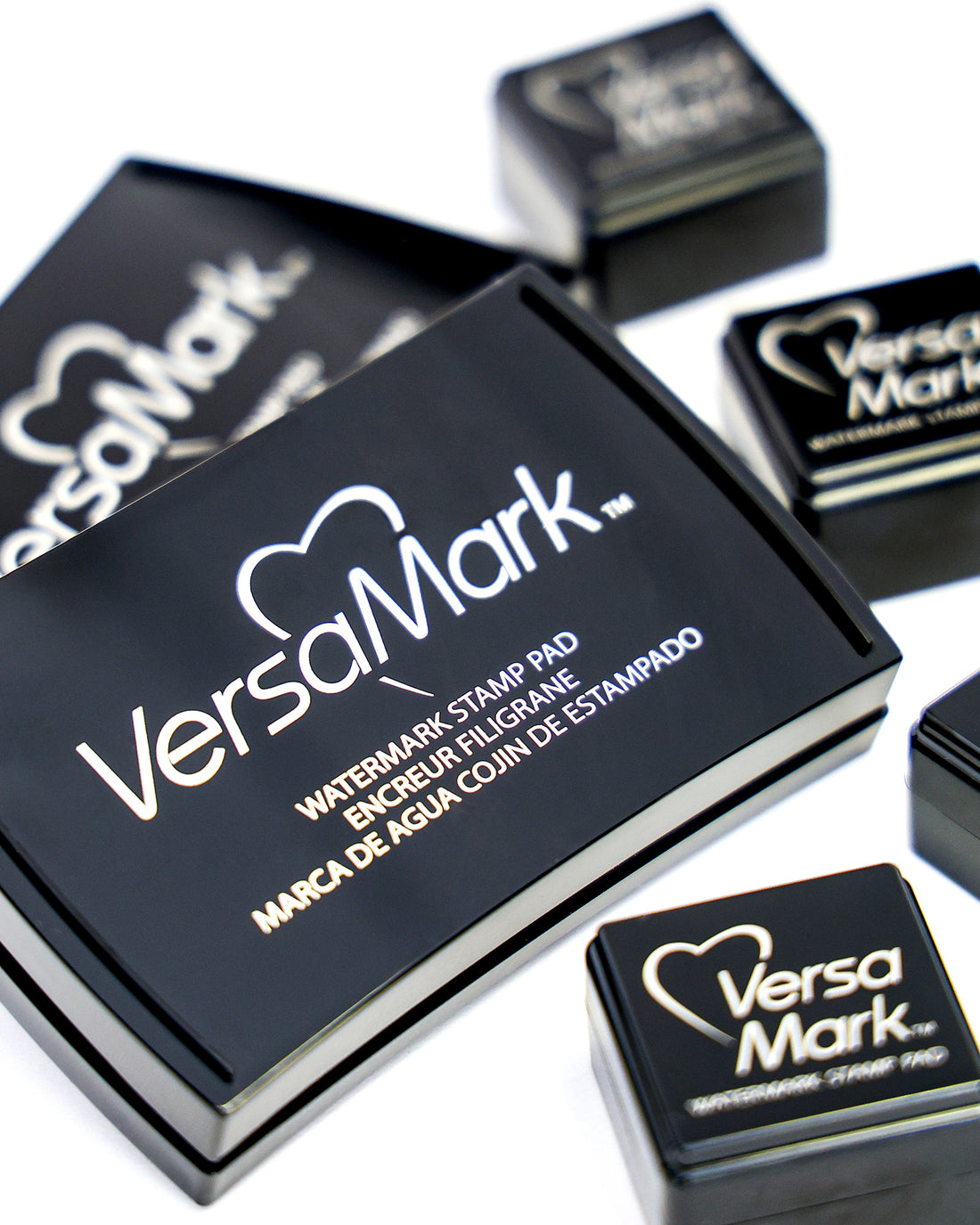 Mehrere schwarze VersaMark-Wasserzeichen-Stempelkissen auf einer weißen Fläche.
