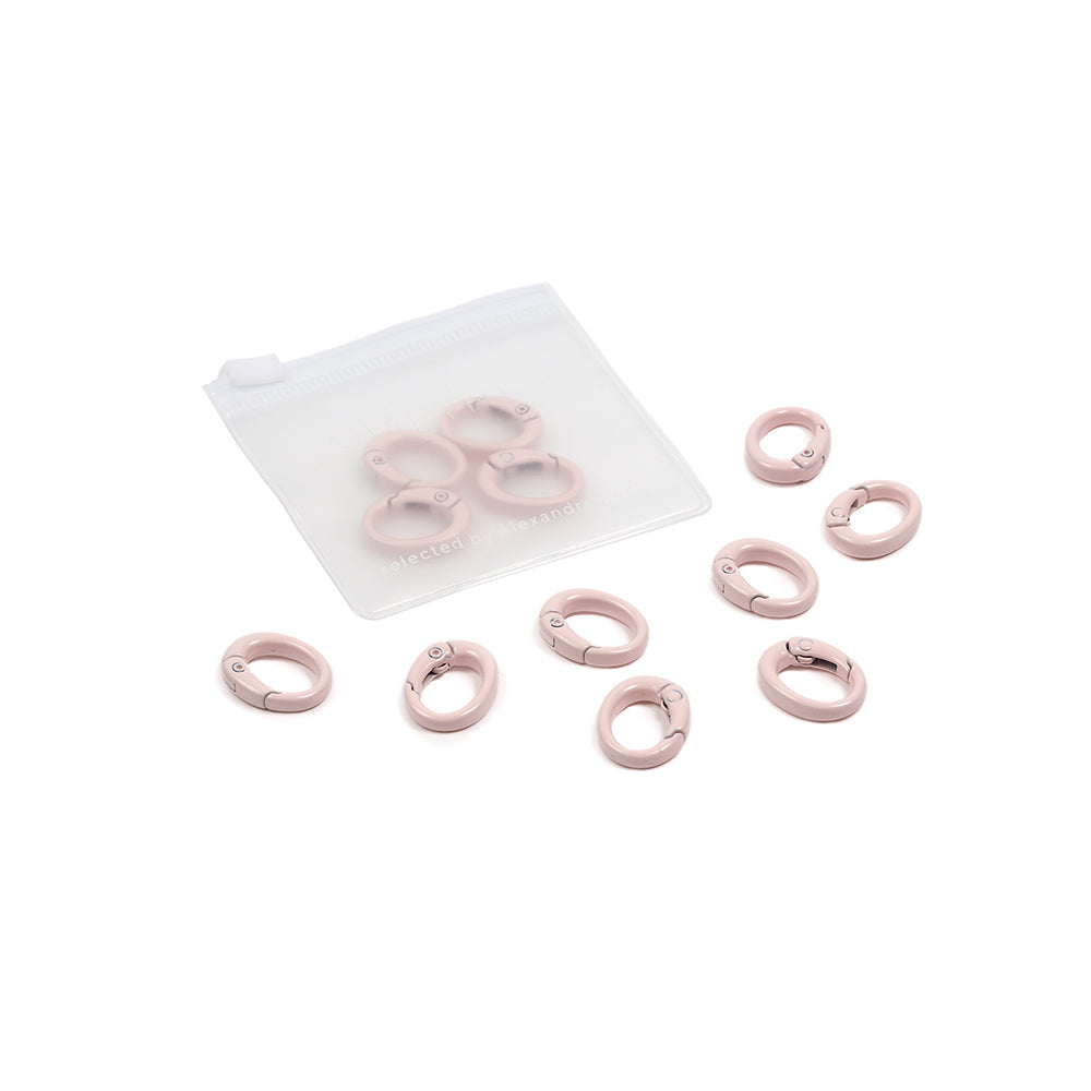 Neun rosa Maschenmarkierer mit ovalen Karabinerhaken und einem durchsichtigen Beutel – ideal für DIY-Projekte wie Handyketten – sind auf weißem Hintergrund abgebildet.