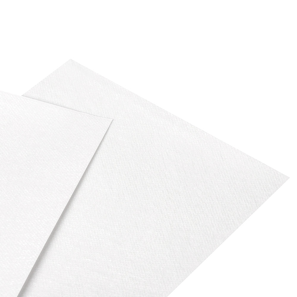 Zwei Bögen strukturiertes weißes DMC Magic Paper überlappen sich auf einem einfarbig weißen Hintergrund, ideal für die mühelose und präzise Übertragung von Stickmotiven.