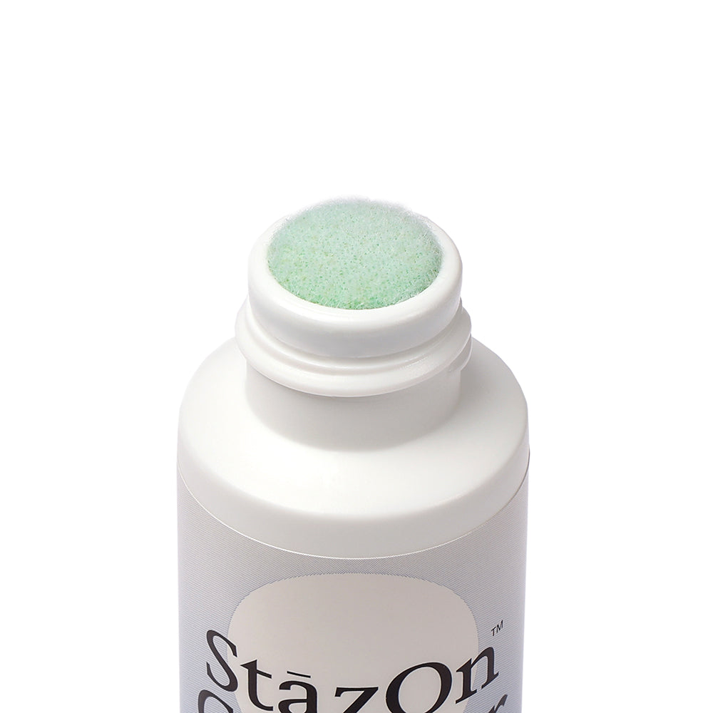 Eine Nahaufnahme einer weißen Tsukineko-Flasche mit grüner Schaumstoffspitze und partiellem "StazOn"-Text, ideal für die Reinigung von Gummistempeln mit dem StazOn Stempelreiniger.