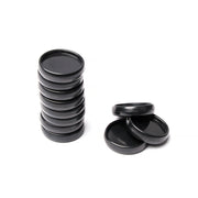 Ein Stapel schwarzer Vaessen-Kunststoffdeckel, perfekt als Bindescheiben für flexible Bindung, steht neben drei losen Deckeln auf weißem Hintergrund.