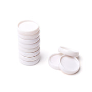 Ein Stapel weißer Vaessen-Plastik-Bindescheiben liegt neben ein paar losen Deckeln auf weißem Hintergrund.