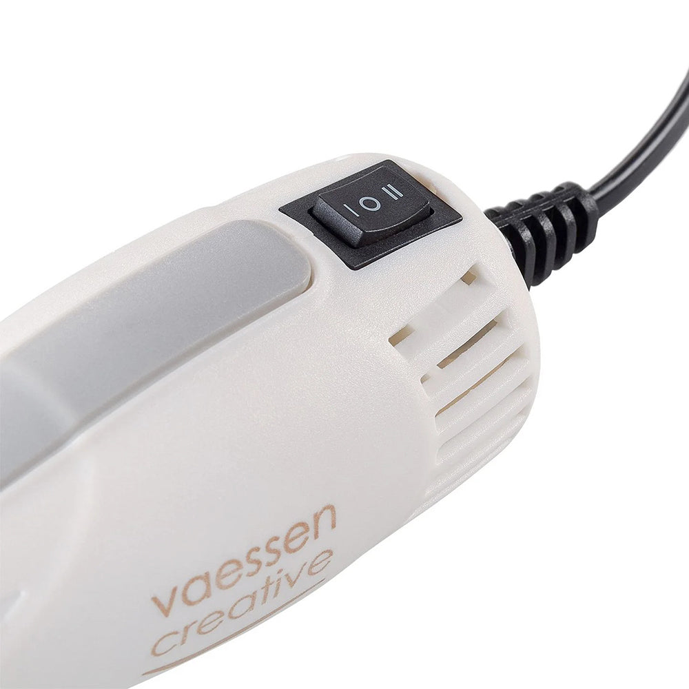 Nahaufnahme einer weißen Vaessen-Prägepistole mit Ein/Aus-Schalter und angeschlossenem Netzkabel.