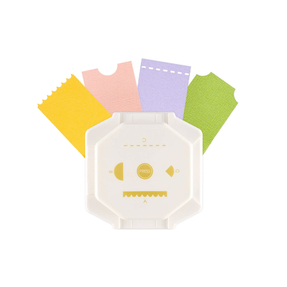 Ein weißer Vaessen Eckenstanzer, der als vielseitiges 4-in-1-Stanzer-Bastelwerkzeug konzipiert ist, wird vor dem Hintergrund von vier bunten Papierstreifen – rosa, lila, gelb und grün – gezeigt.