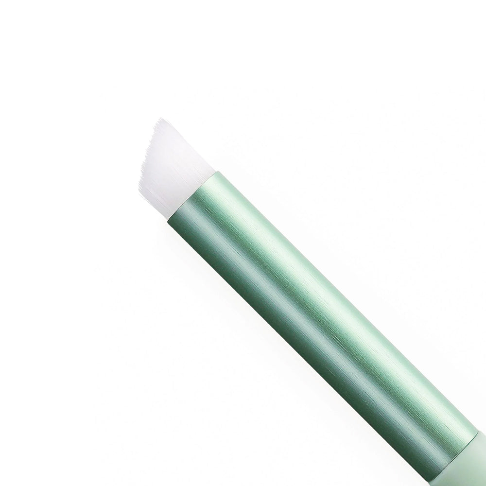 Der Vaessen Detail Blending-Pinsel mit grünem Griff und abgeschrägten weißen Borsten ist auf weißem Grund abgebildet und eignet sich ideal für präzises Auftragen von Make-up oder Mixed-Media-Projekte.