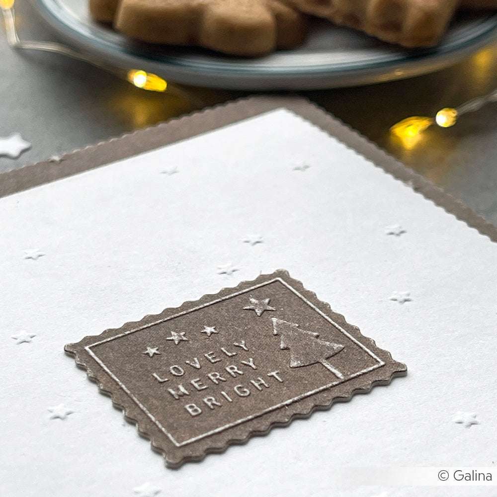 Nahaufnahme einer Karte, die mit dem Schneide- und Prägefolder "Lovely Merry Bright" von Alexandra Renke geprägt wurde, mit Keksen und Lichtern im Hintergrund - perfekt, um Weihnachtswünsche zu versenden.