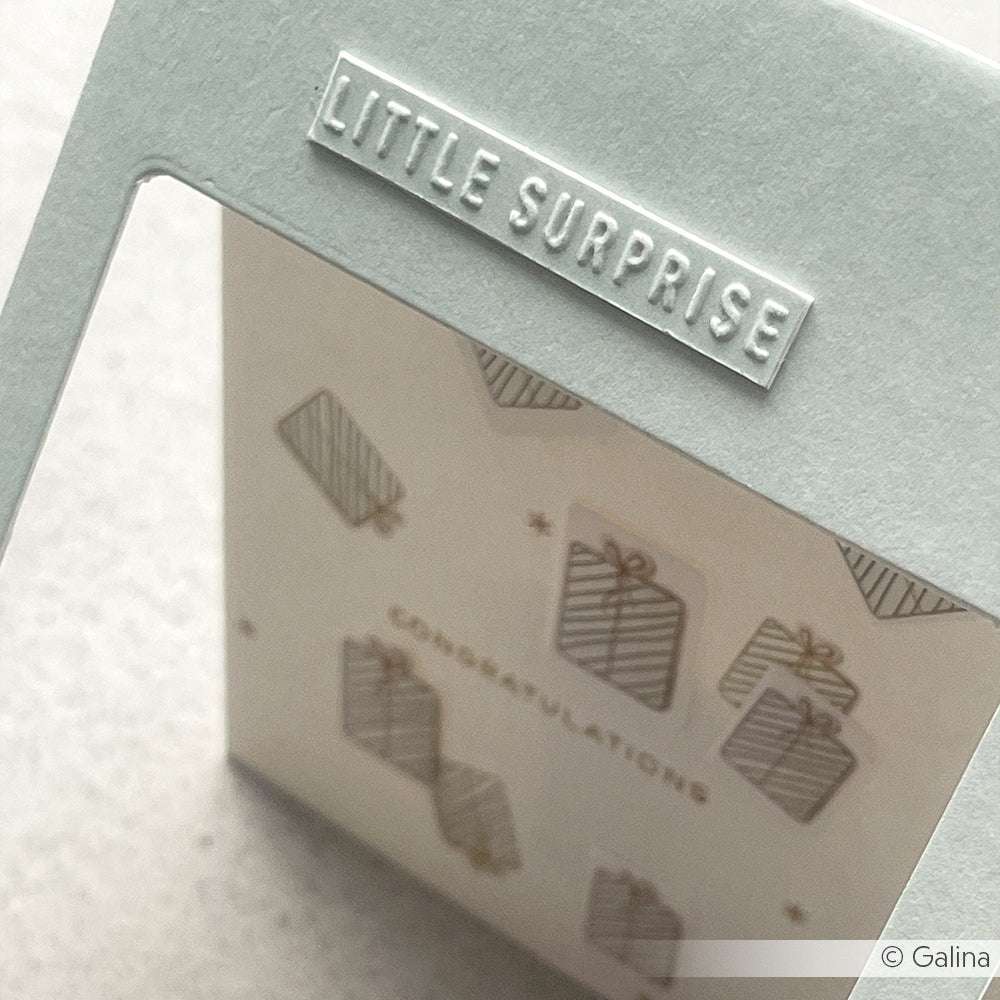 Versenden Sie Weihnachtswünsche mit dieser Karte von Alexandra Renke mit geprägtem "LITTLE SURPRISE"-Text, der mit dem Cut & Emboss Folder hergestellt wurde, sowie verspielt verpackten Geschenken und einer festlichen CONGRATULATIONS-Nachricht.