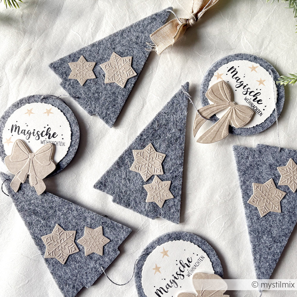 Die grauen Filzornamente in Baum- und Kreisform von Alexandra Renke werden mit PAPPcut Tanne gefertigt, mit Sternen, Schleifen und Magischen Weihnachtsanhängern verziert und mit Buchbindentechniken fertiggestellt.