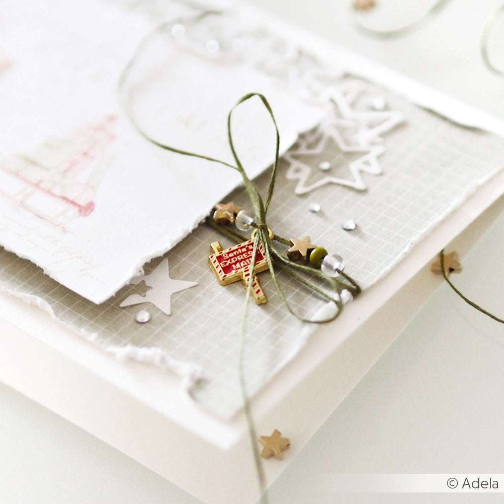 Handgefertigte Karte von Alexandra Renke mit geschichtetem Papier, Sternformen, grünem Garn, Perlen und einer roten Buchbinde - ideal für einzigartige Papierprojekte und kreative Anhänger.