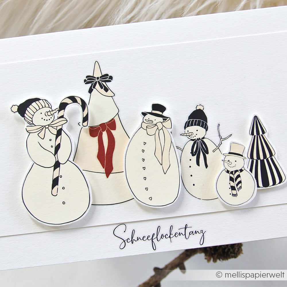 Fünf handgezeichnete Schneemänner und Bäume mit Mützen und Schals auf einer weißen Karte mit "Schneeflockentanz" - ideal für Alexandra Renke Festlichkeiten Winterwald-Rubbel oder zum Hinzufügen von Winterwald-Motiven zu Ihren Transferfolien-Bastelprojekten.