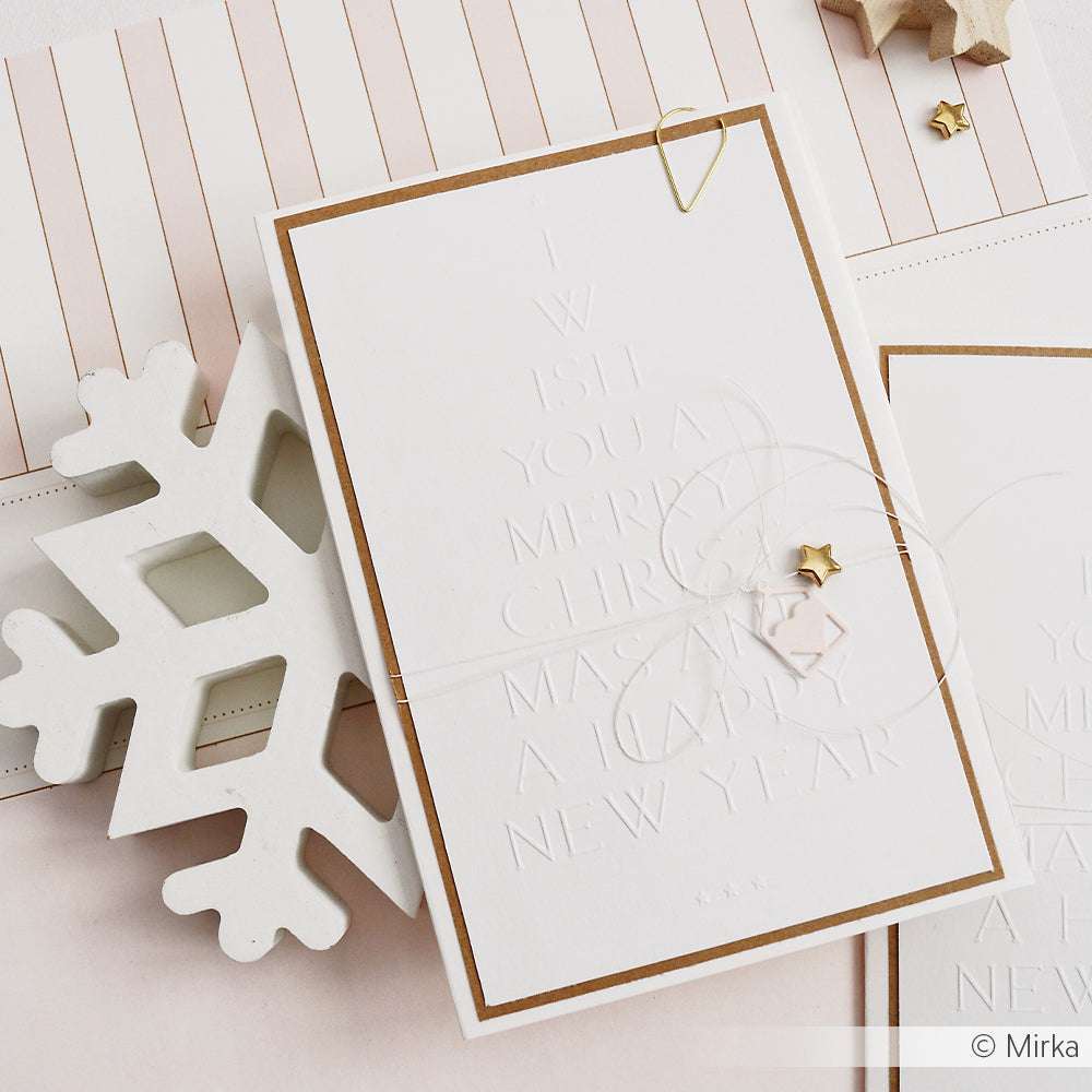 Hochwertige weiße Weihnachtskarte von Alexandra Renke mit geprägtem "Typo Tanne Merry Christmas"-Text, goldenem Rand, Sternenakzenten und Schneeflockenmotiv. Verarbeitet mit edlem Designpapier und einem Prägefolder für einen raffinierten Look.