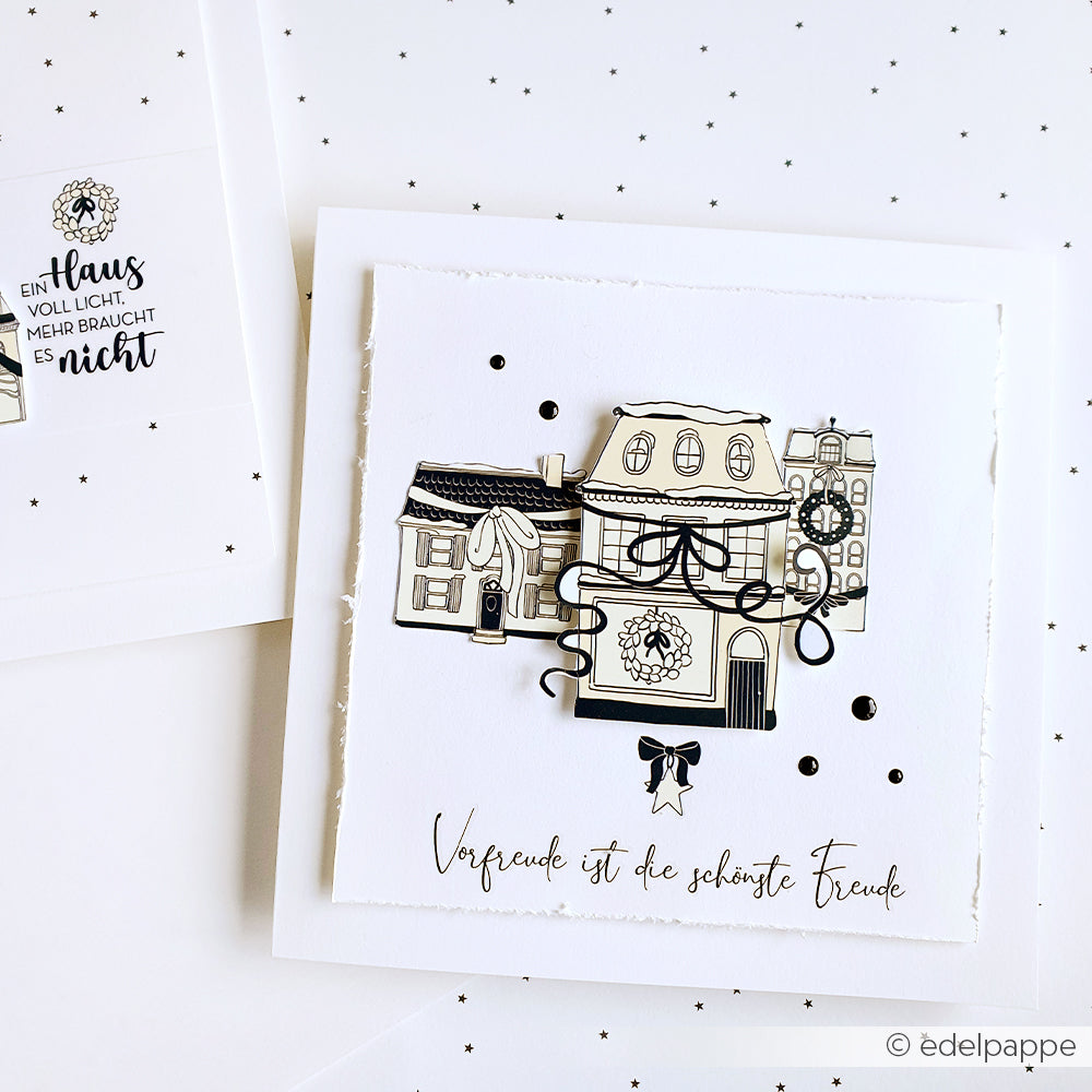 Handgefertigte Karte von Alexandra Renke mit schwarzen und weißen Häusern, einem Kranz und deutschem Text auf weißem gepunktetem Hintergrund - ideal für Bastelprojekte Motive oder zur Aufwertung von Projekten mit Transferfolien Basteln.