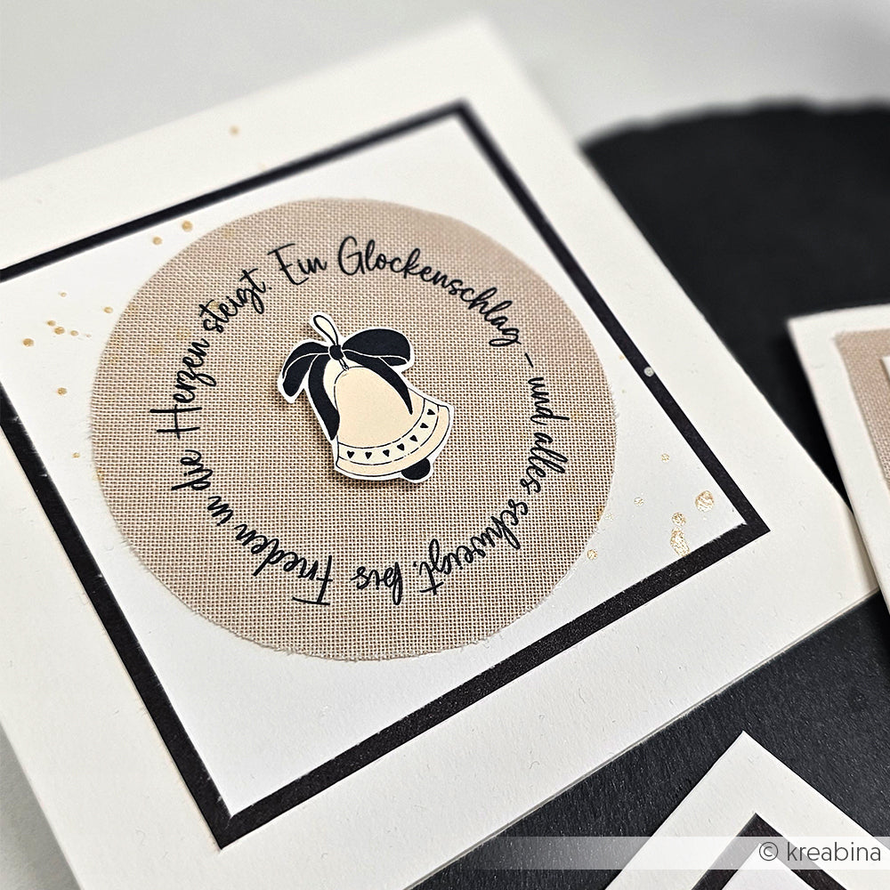 Handgefertigte Karte von Alexandra Renke mit einer Glocke und deutschem Text in einem Kreis auf Beige mit Goldspritzern - ideal für Adventslicht-Motive oder zum Aufpeppen Ihrer Projekte mit Transferfolien Basteln.