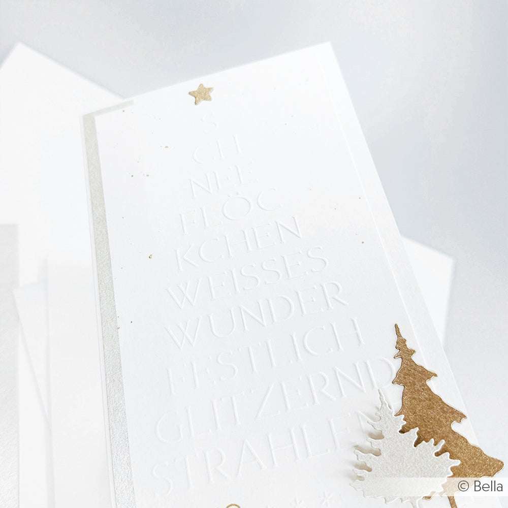 Weiße Karte mit geprägtem deutschen Text mit dem Prägefolder Alexandra Renke Typo Tanne Weißes Wunder, veredelt mit einem goldenen Stern und einem goldenen Weihnachtsbaumschmuck unten rechts.
