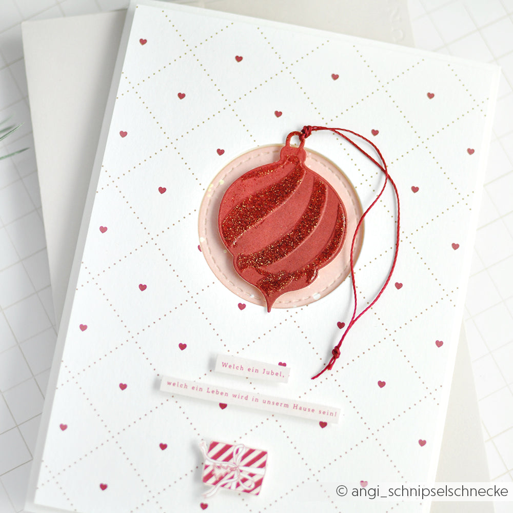 Handgefertigte Karte von Alexandra Renke mit roten Glitzer-Festtagskugeln, kleinen roten Herzen und deutschem Text auf weißem, gemustertem Hintergrund. Gefertigt mit Stanzsystemen für gestochen scharfe Details.