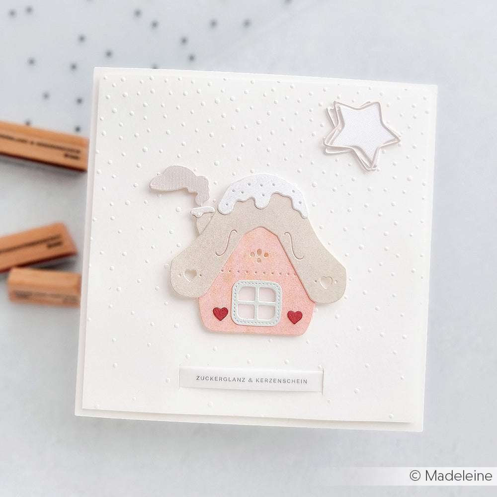 Quadratische Karte von Alexandra Renke mit einem rosafarbenen Lebkuchenhaus mit weißem Dach, roten Herzen und einem weißen Stern auf gepunktetem Hintergrund - ideal für die Kombination mit Designpapier oder einem Prägefolder für zusätzlichen Charme.
