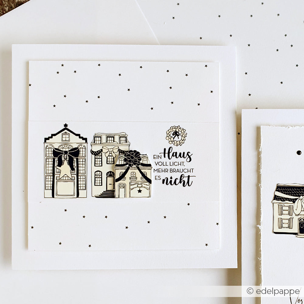 Minimalistische Weihnachtskarte von Alexandra Renke mit illustrierten Häusern, Sternen und dem deutschen Text "Ein Haus voll Licht, mehr braucht es nicht." Ideal für Bastelprojekte Winter oder um Rub-On Festlichkeiten Winterheim Akzente zu setzen.