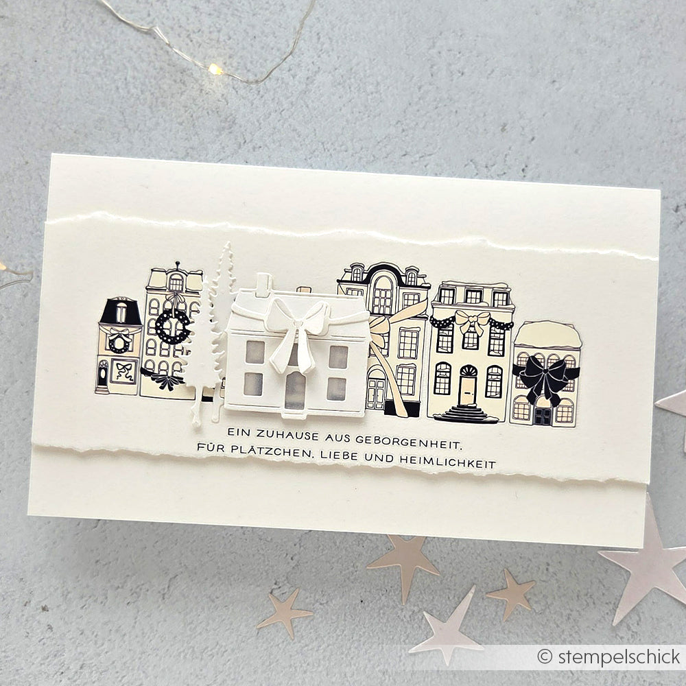 Eine handgefertigte Karte von Alexandra Renke mit illustrierten Häusern, Bäumen, Sterndekorationen und deutschem Text auf weißem Hintergrund - ideal für Rub-On Festlichkeiten Winterheim und Transferfolien Basteln Motive Schriften Muster.