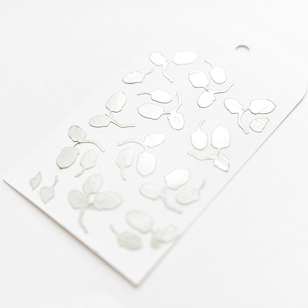 Bogen mit silbermetallischen Stickern in Form von abstrakten Blättern auf weißem Hintergrund von Alexandra Renke - ideal für Schablonen Papierprojekte oder als wiederverwendbare Stencils in Ihrem kreativen Handwerk.