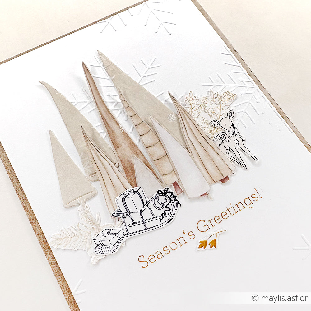Handgefertigte Karte von Alexandra Renke mit Papierbäumen, Hirschen, Schlitten und dem Text "Season's Greetings!" auf weißem, geprägtem Hintergrund - perfekt für Bastelprojekte zu Weihnachten oder in Kombination mit Rub-On Weihnachtszauber für festliches Flair.