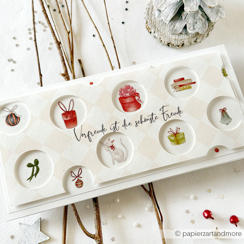 Eine festliche Karte von Alexandra Renke mit Geschenken, Ornamenten, einer Katze und dem Spruch "Vorfreude ist die schönste Freude" - ideal für Transferfolien-Basteln oder das Hinzufügen von Christbaumzauber-Motiven zu Ihren Weihnachtsbasteleien.