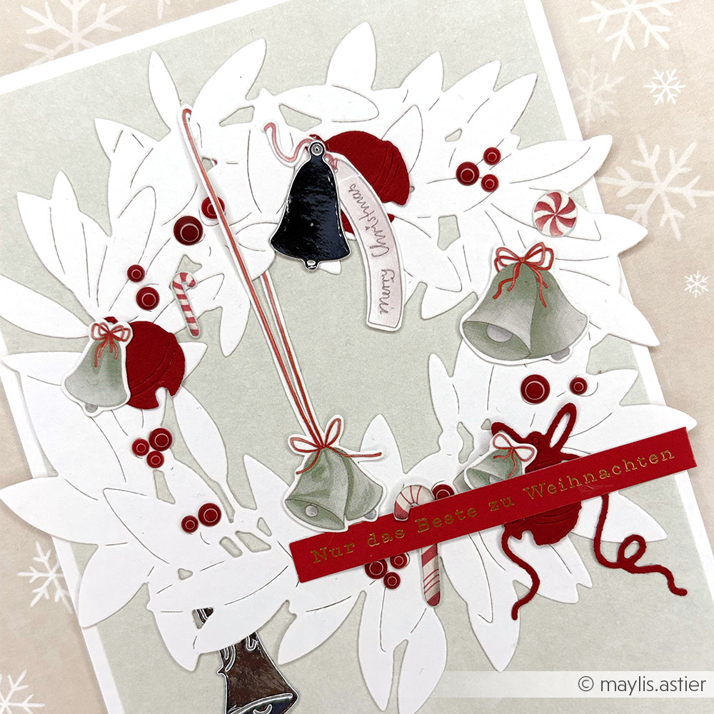 Die festliche Karte von Alexandra Renke zeigt einen weiß-roten Adventskranz mit Glocken, Beeren, Zuckerstangen und "Frohe Weihnachten" - ideal für Bastelprojekte oder um Weihnachtsgrüße mit Christbaumzauber zu ergänzen.