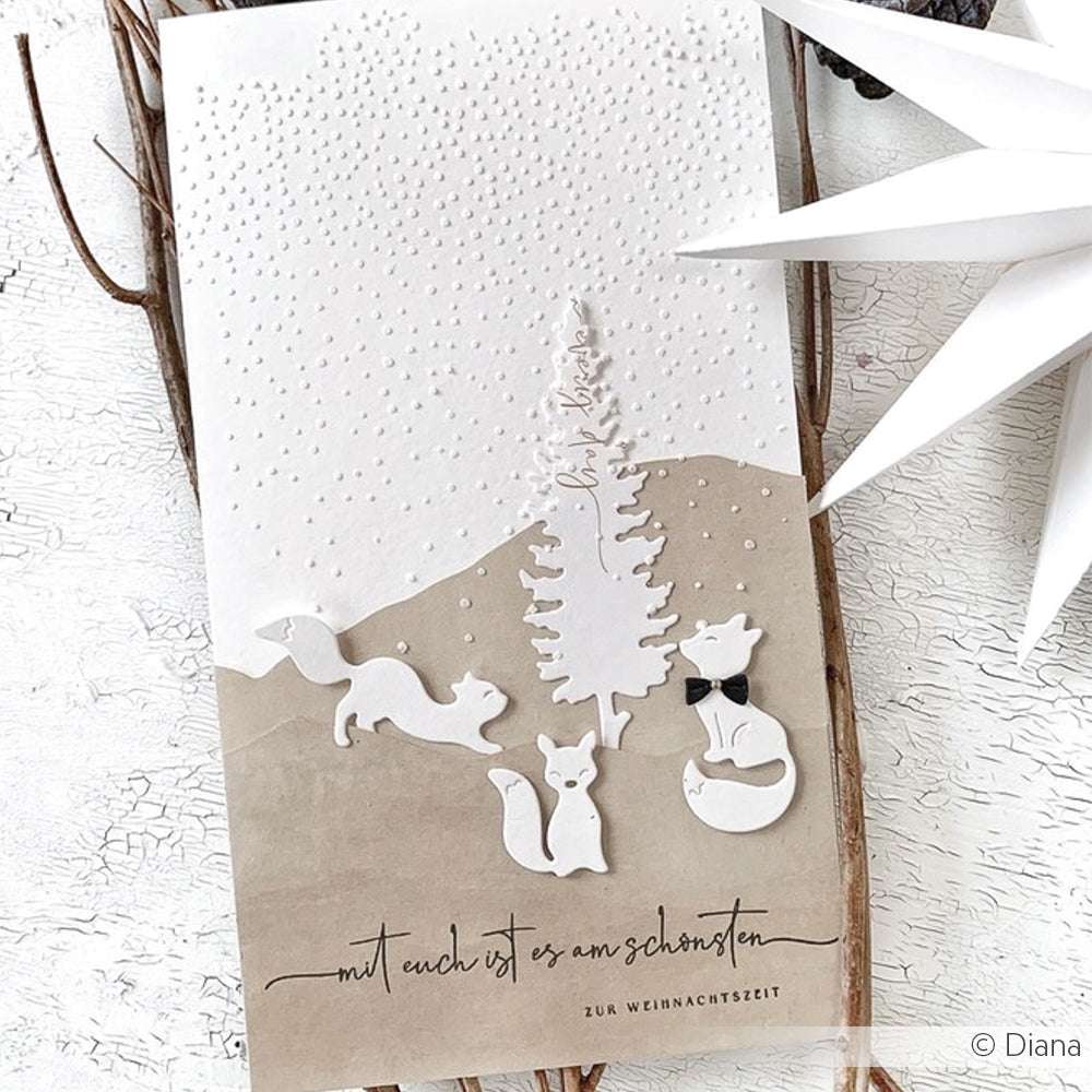Eine winterliche Karte von Alexandra Renke mit weißen Bäumen, Tieren und Schnee, mit deutschem Text am unteren Rand, hergestellt mit Stencil Schneefall für feine Details.