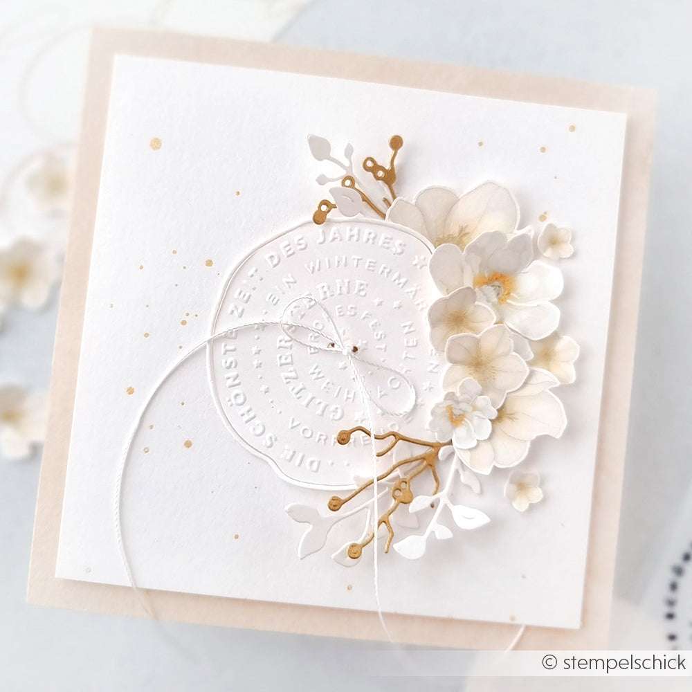 Quadratische weiße Karte von Alexandra Renke aus Designpapier mit geprägtem Text, zarten Papierblumen und goldenen Akzenten auf einem beigen Hintergrund. Mit Embossing Folder Details und Typo Kreis Schönste Zeit für ein elegantes Finish.
