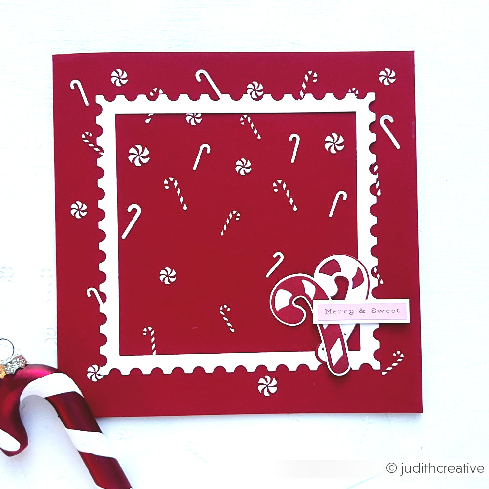Rote quadratische Karte mit einem Zuckerstangen-Regen-Motiv, einem Briefmarkenrahmen und dem Merry & Sweet-Etikett.