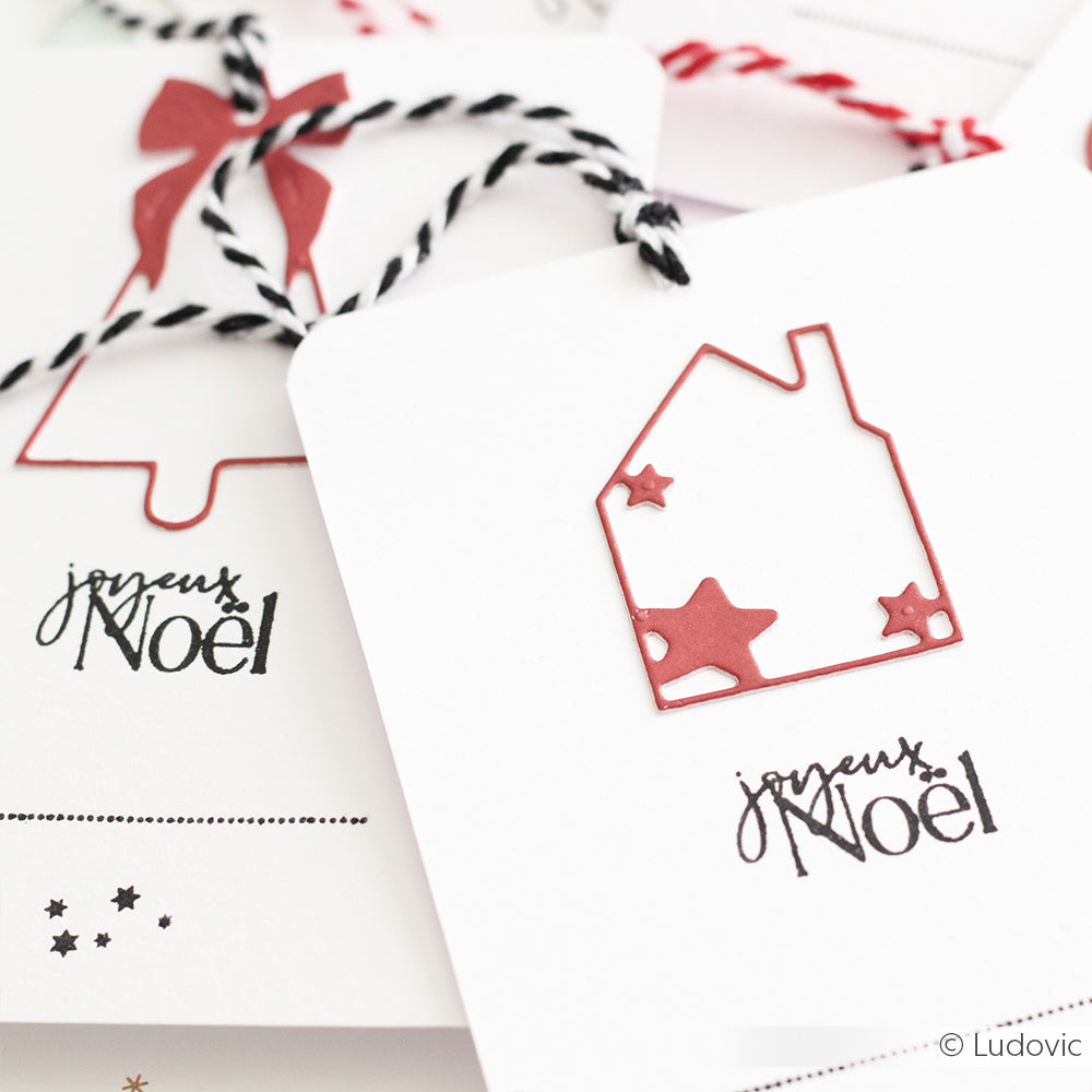Die weißen Weihnachtskarten von Alexandra Renke mit Joyeux Noël, schwarzem Garn und roten Haus- und Sternausschnitten passen perfekt zu einem Clear Stamp Set oder Photopolymer-Stempel mit "Frohe Weihnachten" für zusätzlichen festlichen Charme.
