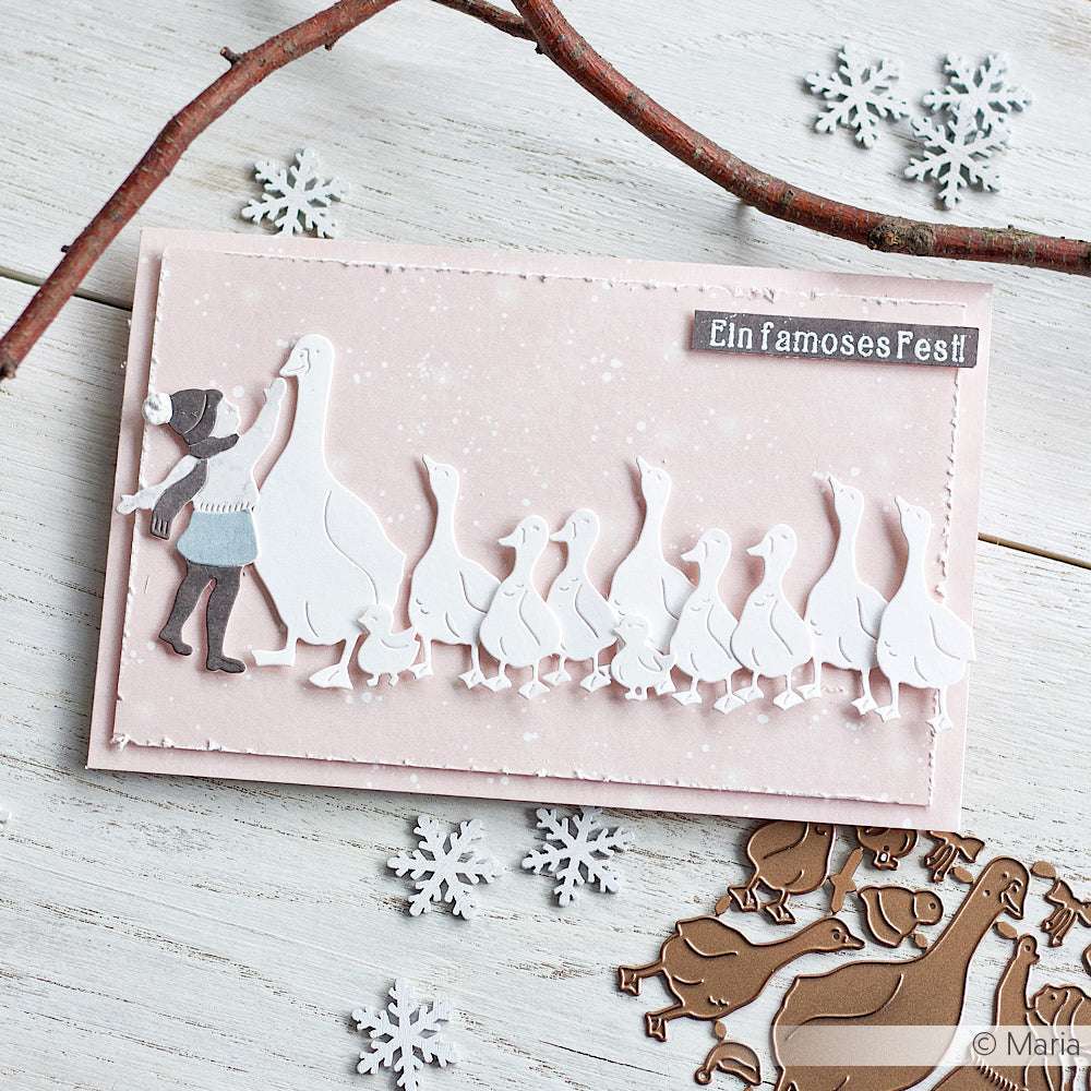 Handgefertigte Karte von Alexandra Renke mit einem Mädchen und Gänsen, dem Gruß "Frohe Weihnachten" und Schneeflocken-Akzenten, hergestellt mit einem Photopolymer-Stempel auf einer weißen Holzoberfläche.