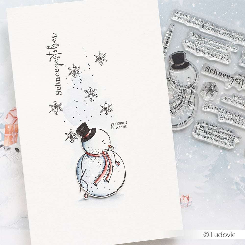 Handgemachte Karte mit Schneemann, Schneeflocken und deutschem Text. Im Hintergrund ist das klare Photopolymer-Stempelset Schneegestöber von Alexandra Renke zu sehen.