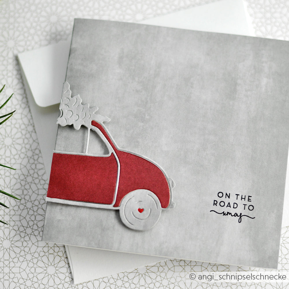 Alexandra Renke Grußkarte mit einem roten Auto mit Weihnachtsbaum und "ON THE ROAD TO xmas" auf grauem Hintergrund, ideal für die Kombination mit Ihren Lieblingsmotiven von Clear Stamp oder Photopolymer Stempel Holiday.