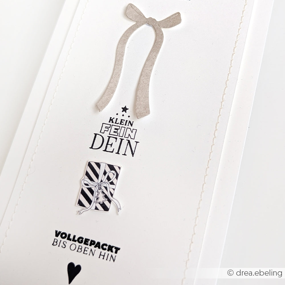 Eine minimalistische Karte von Alexandra Renke mit einer Schleife, einem gestreiften Geschenk und dem deutschen Text "KLEIN FEIN DEIN" & "VOLLGEPACKT BIS OBEN HIN" - perfekt für Papierprojekte mit Ihren Lieblingsmotiven von Clear Stamp oder Photopolymer Stempel.