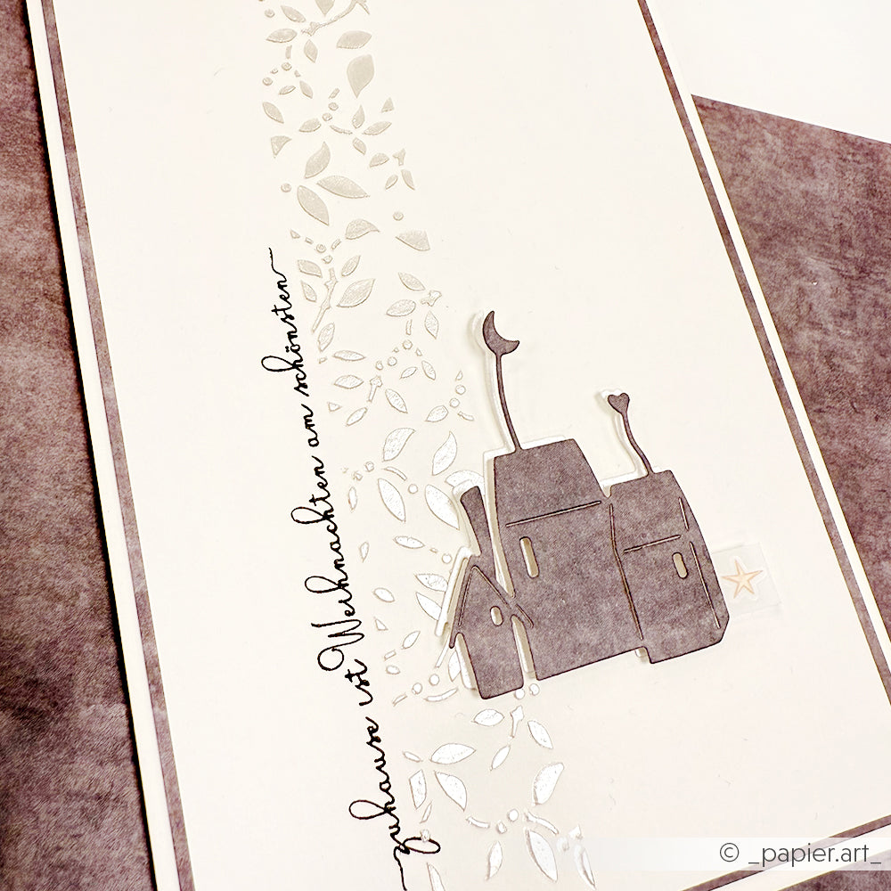 Handgefertigte Karte von Alexandra Renke mit einem grauen Haus, silbernen Blättern und deutscher Kalligrafie auf weißem und grauem Hintergrund - hergestellt mit einem Clear Stamp für präzise Details.