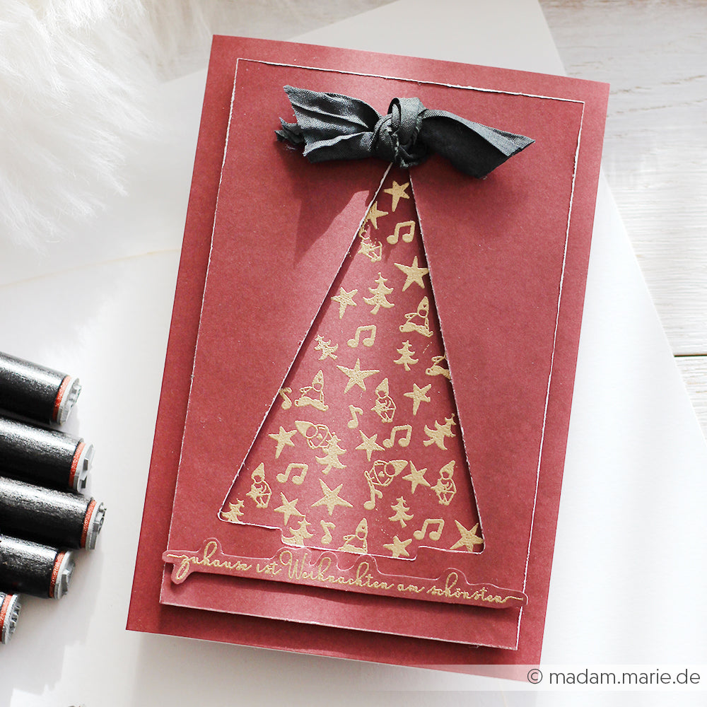 Rote Weihnachtskarte von Alexandra Renke mit einem goldfarbenen gemusterten Baum, festlichen Symbolen im Inneren der Form und einer schwarzen Schleife obenauf. Erstellt mit Papierprojekte Photopolymer Stempel für gestochen scharfe, detaillierte Designs.